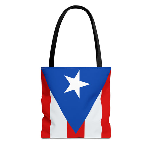 A tote bag featuring the Puerto Rican flag design with a white star on a blue background, horizontal red and white stripes, and black handles.