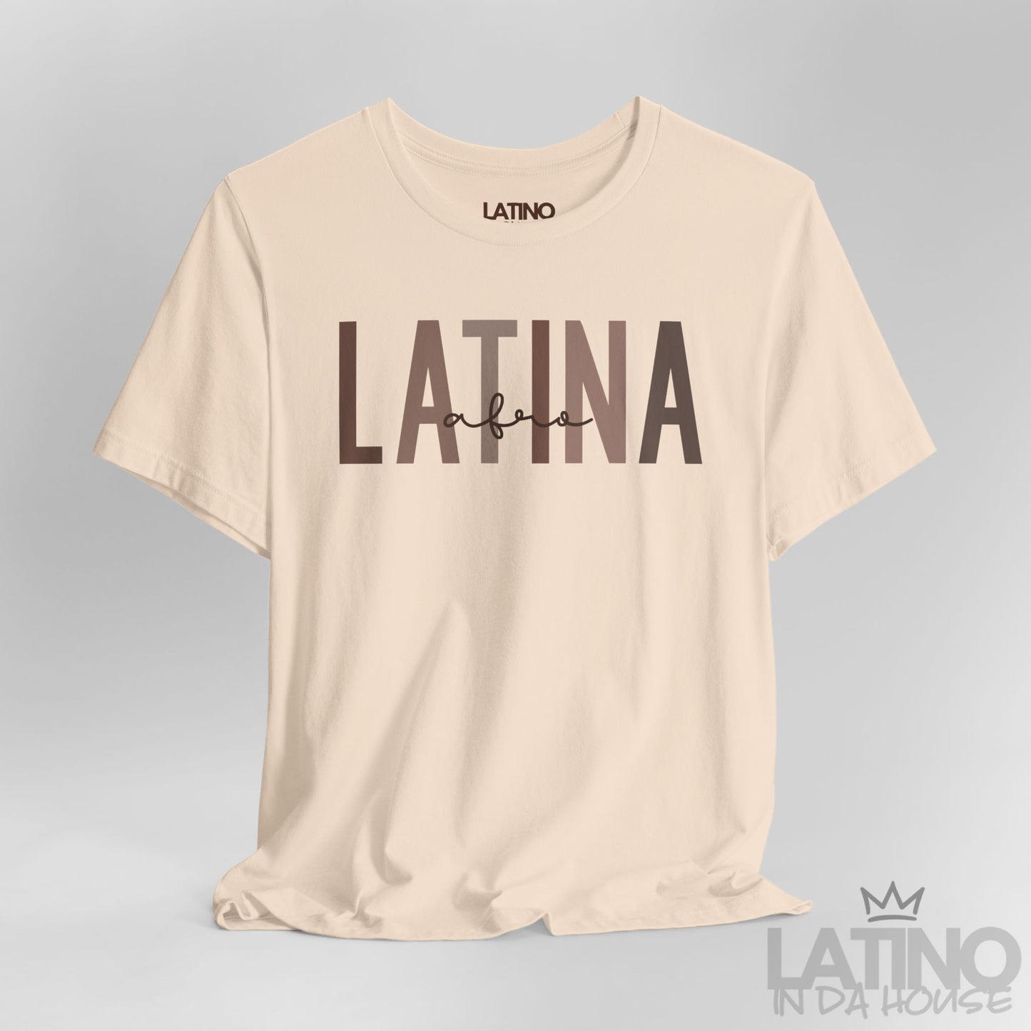 Close-up of Afro Latina T-Shirt design in bold brown text on soft cream cotton fabric. Latino In Da House