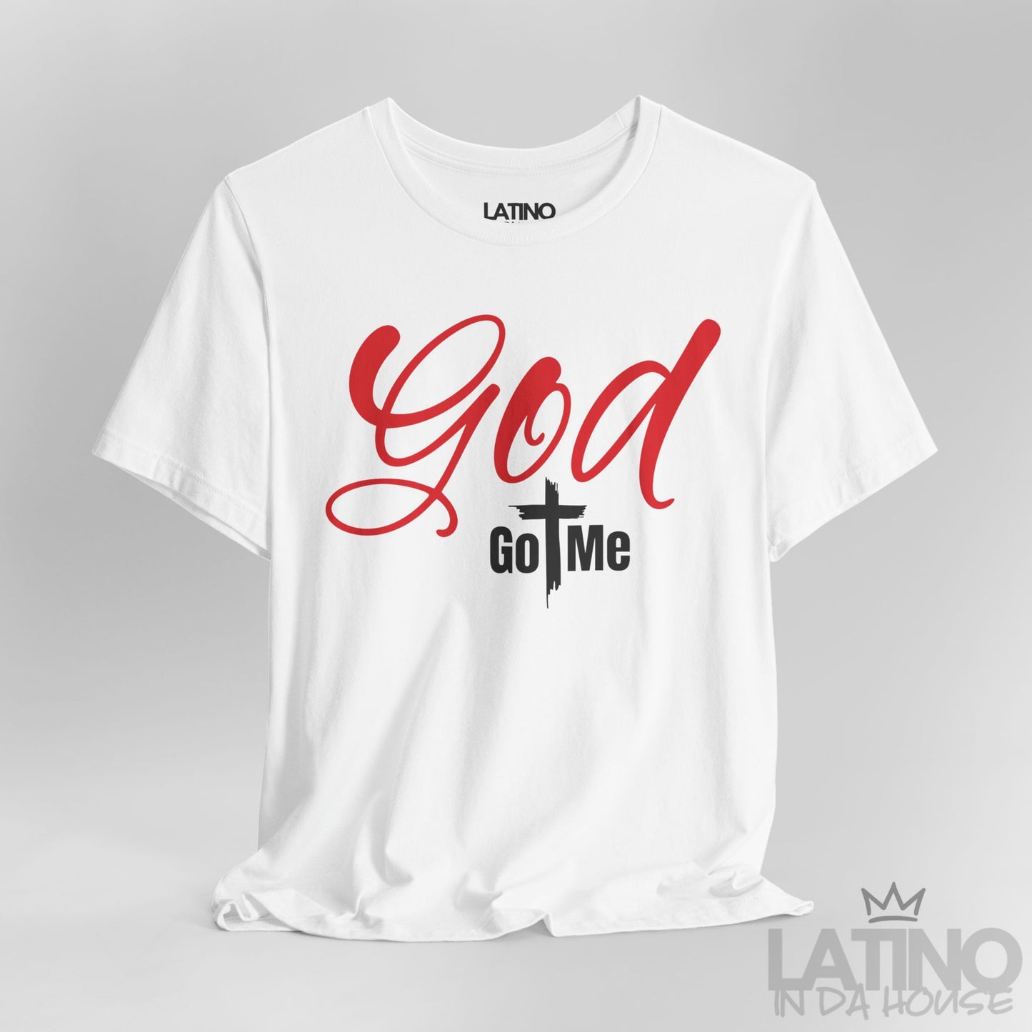 Close-up of God Got Me White T-Shirt showing bold red text and cross-centered design. Latino In Da House