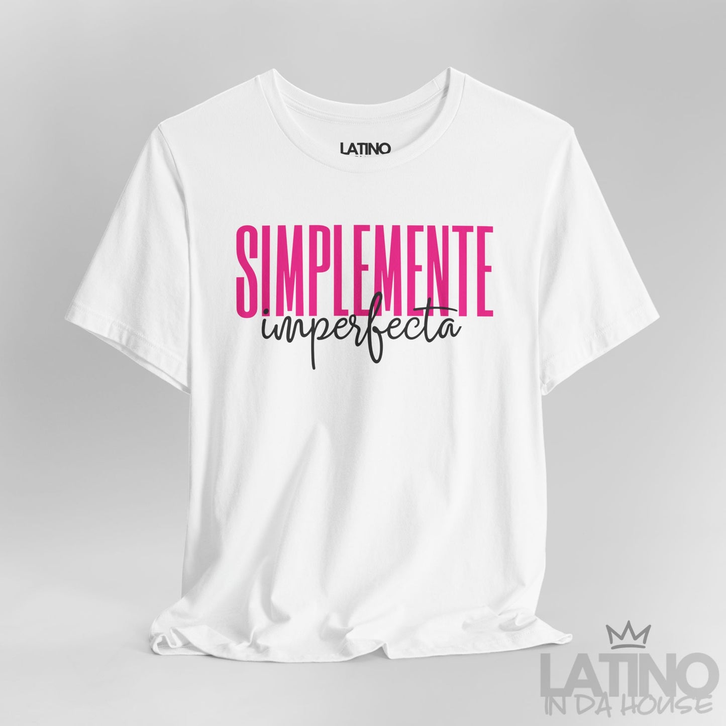 Closeup of white T-shirt with bold pink and black text reading “Simplemente Imperfecta” – Latino In Da House