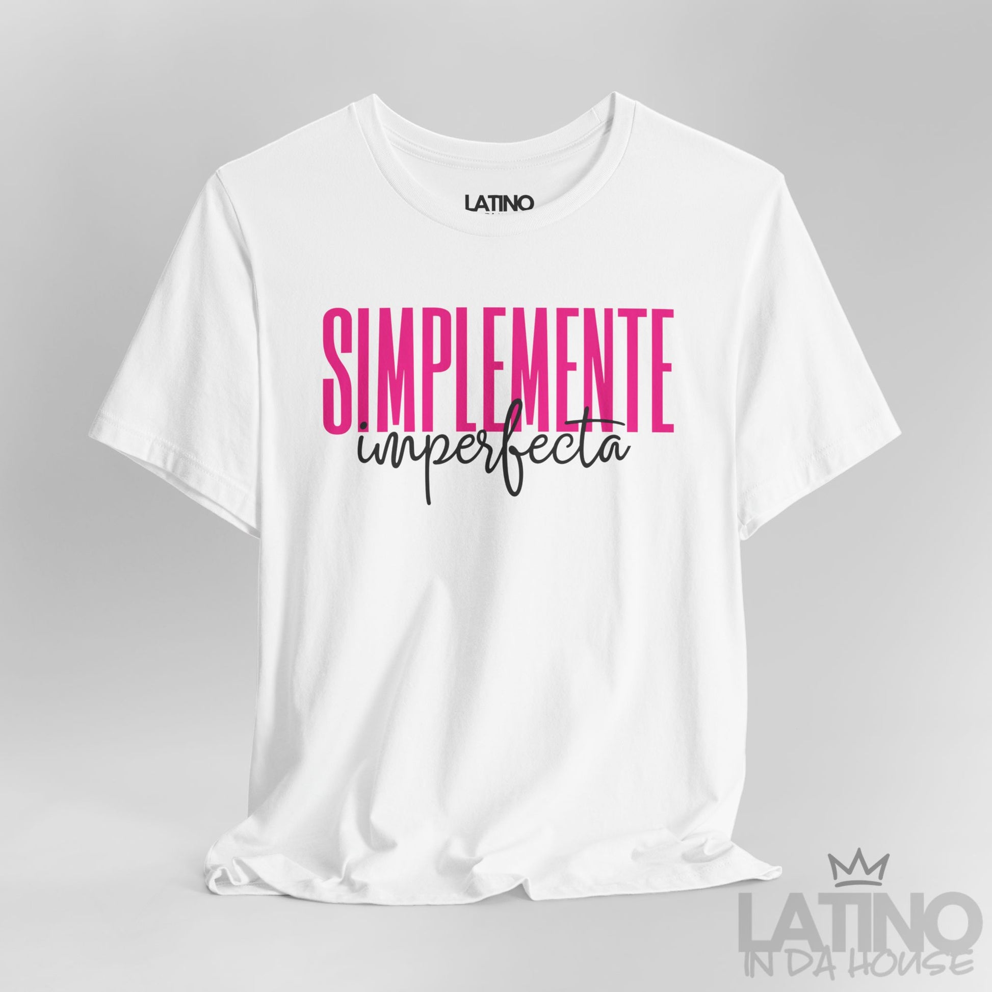 Closeup of white T-shirt with bold pink and black text reading “Simplemente Imperfecta” – Latino In Da House