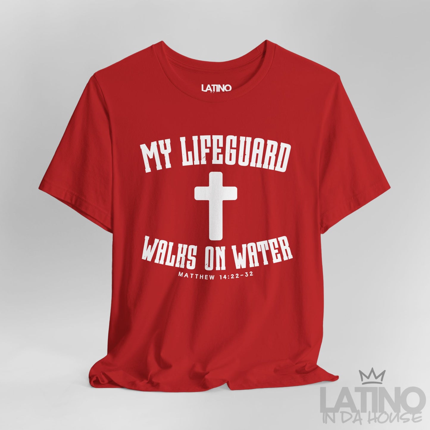 Close up red t-shirt with white cross and text ‘My Lifeguard Walks on Water – Matthew 14:22–32.’ Latino In Da House