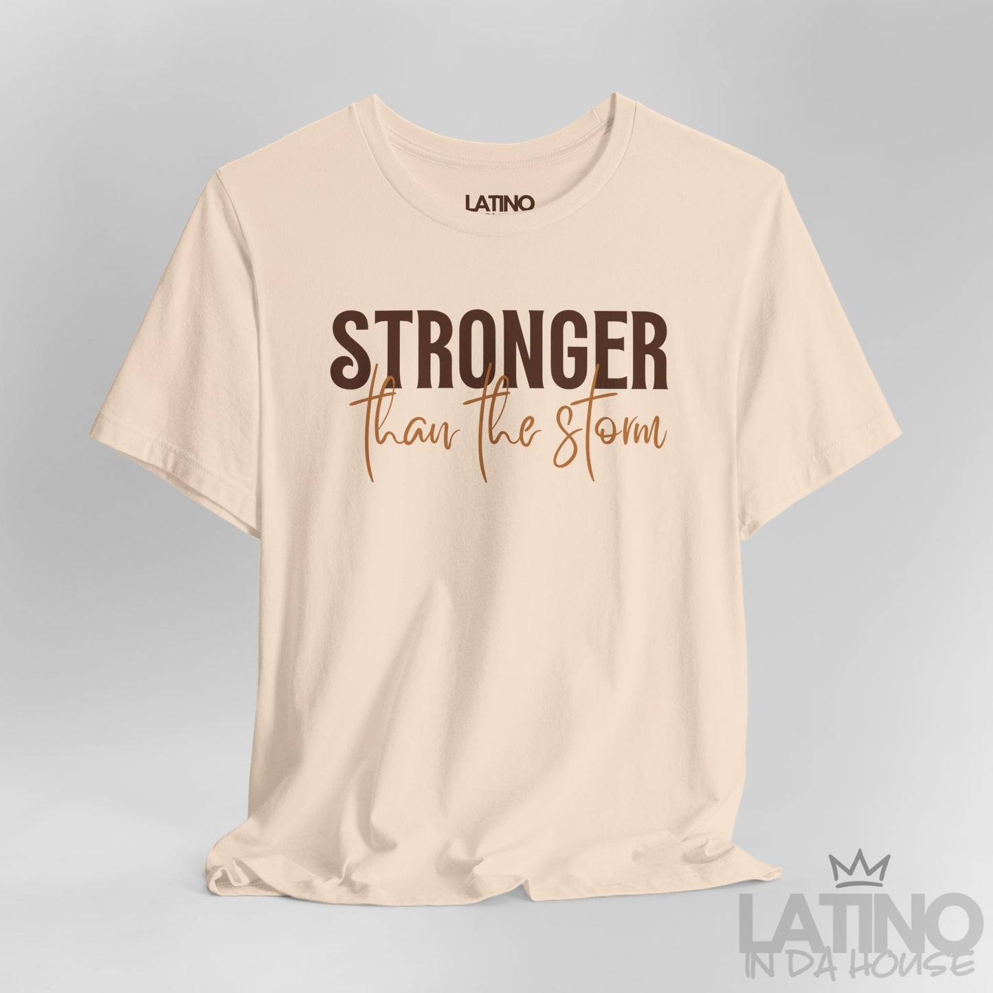 Close Up Stronger Than The Storm tee in soft cream – brown and caramel typography. Latino In Da House