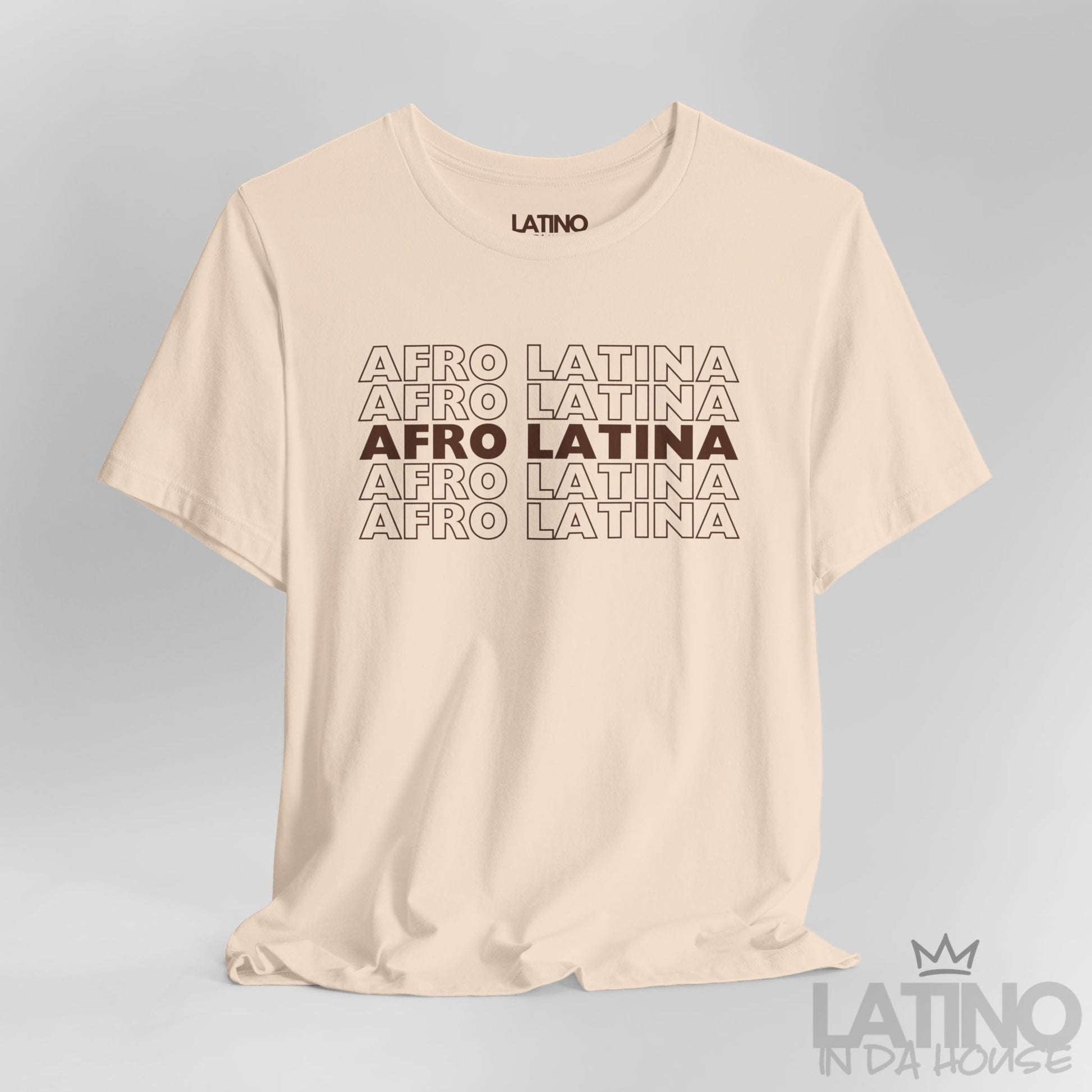 Close-up of Afro Latina T-Shirt design in brown text on cream fabric. Latino In Da House 
