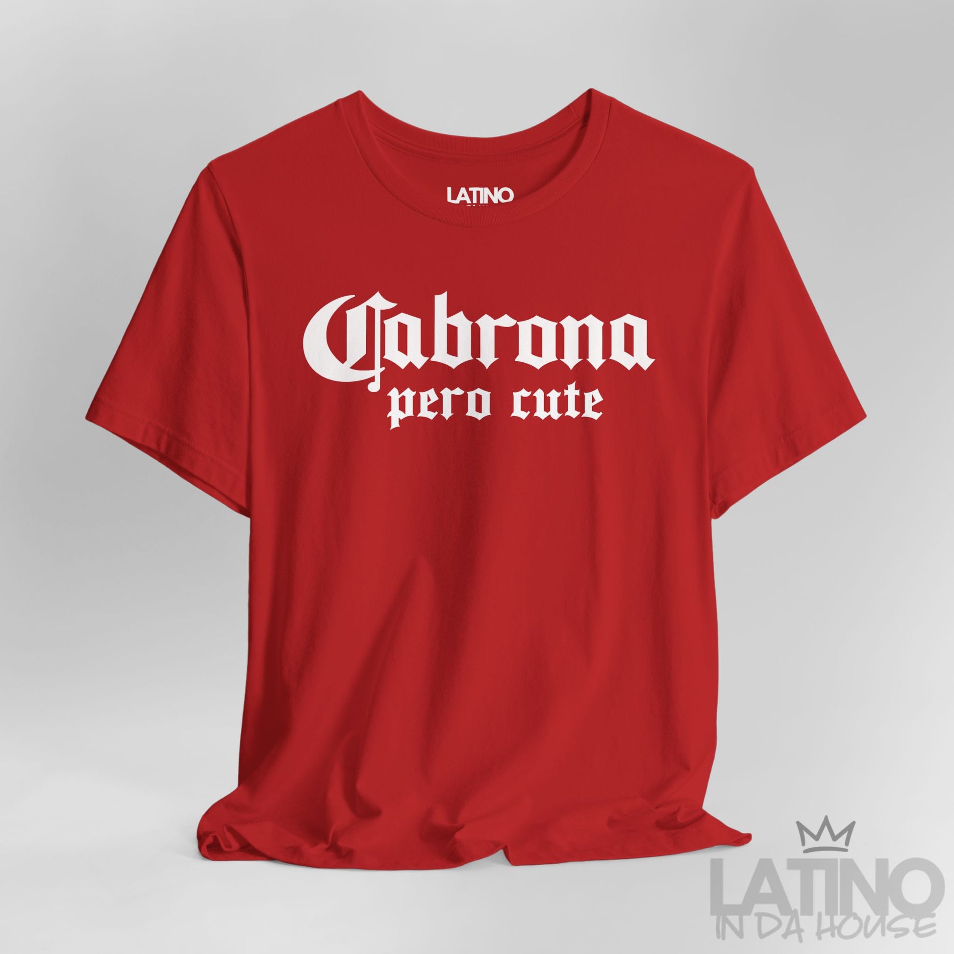 Close-up of red “Cabrona Pero Cute” T-Shirt white gothic text. Latino In Da House