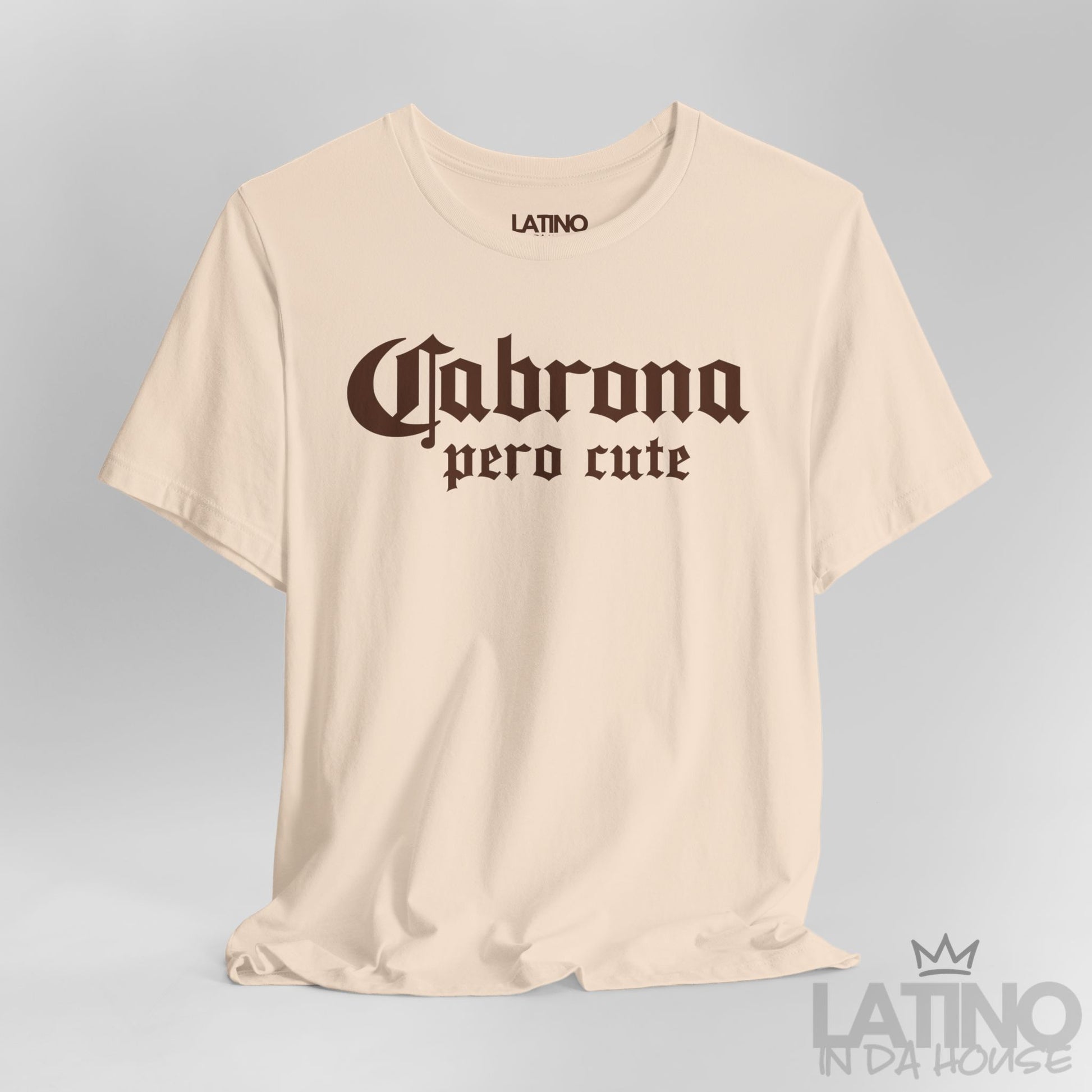 Close-up of soft cream “Cabrona Pero Cute” T-Shirt white gothic text. Latino In Da House 