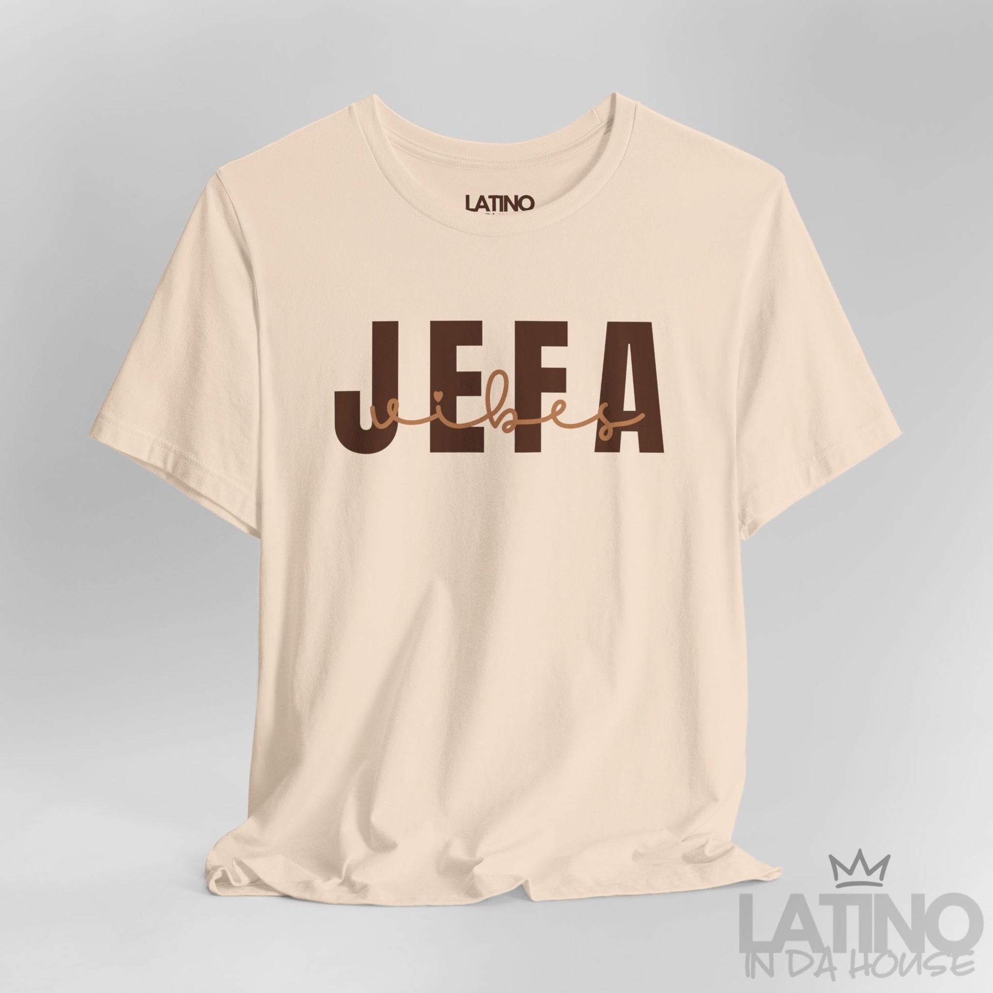 Close-up of Jefa Vibes text design in brown block and script letters on soft cream T-shirt. Latino In Da House 