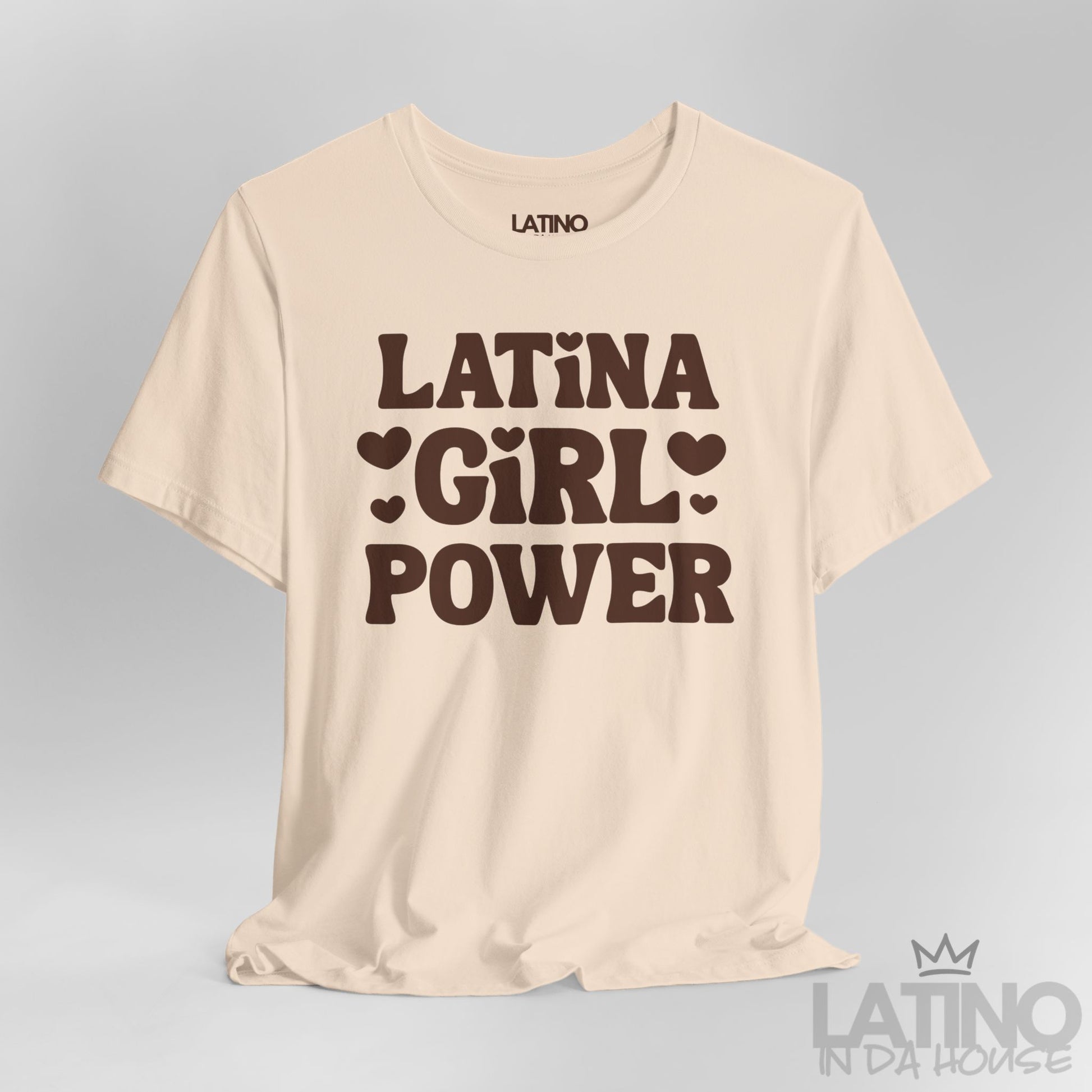 Close-up of soft cream T-shirt with brown “Latina Girl Power” text and heart accents. Latino In Da House 