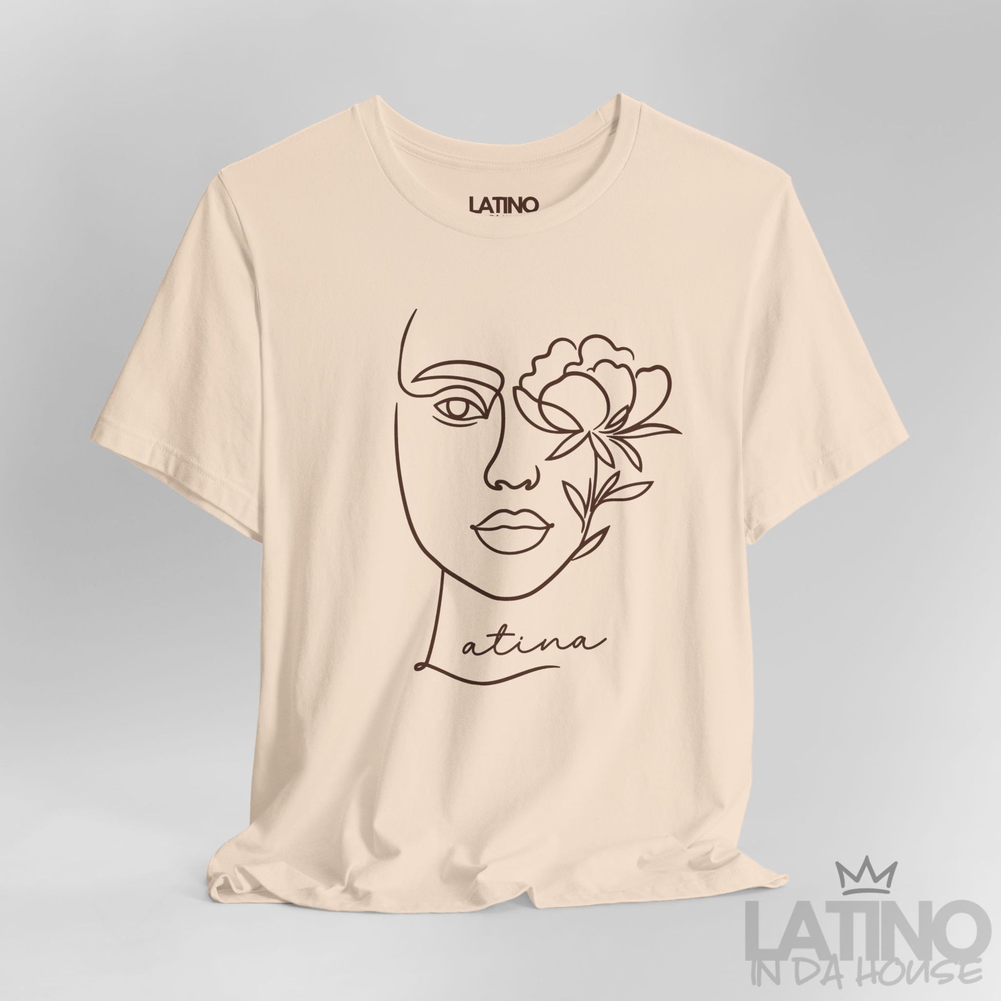 Close-up of Latina T-shirt with minimalist face and flower line art in Soft Cream. Latino In Da House 