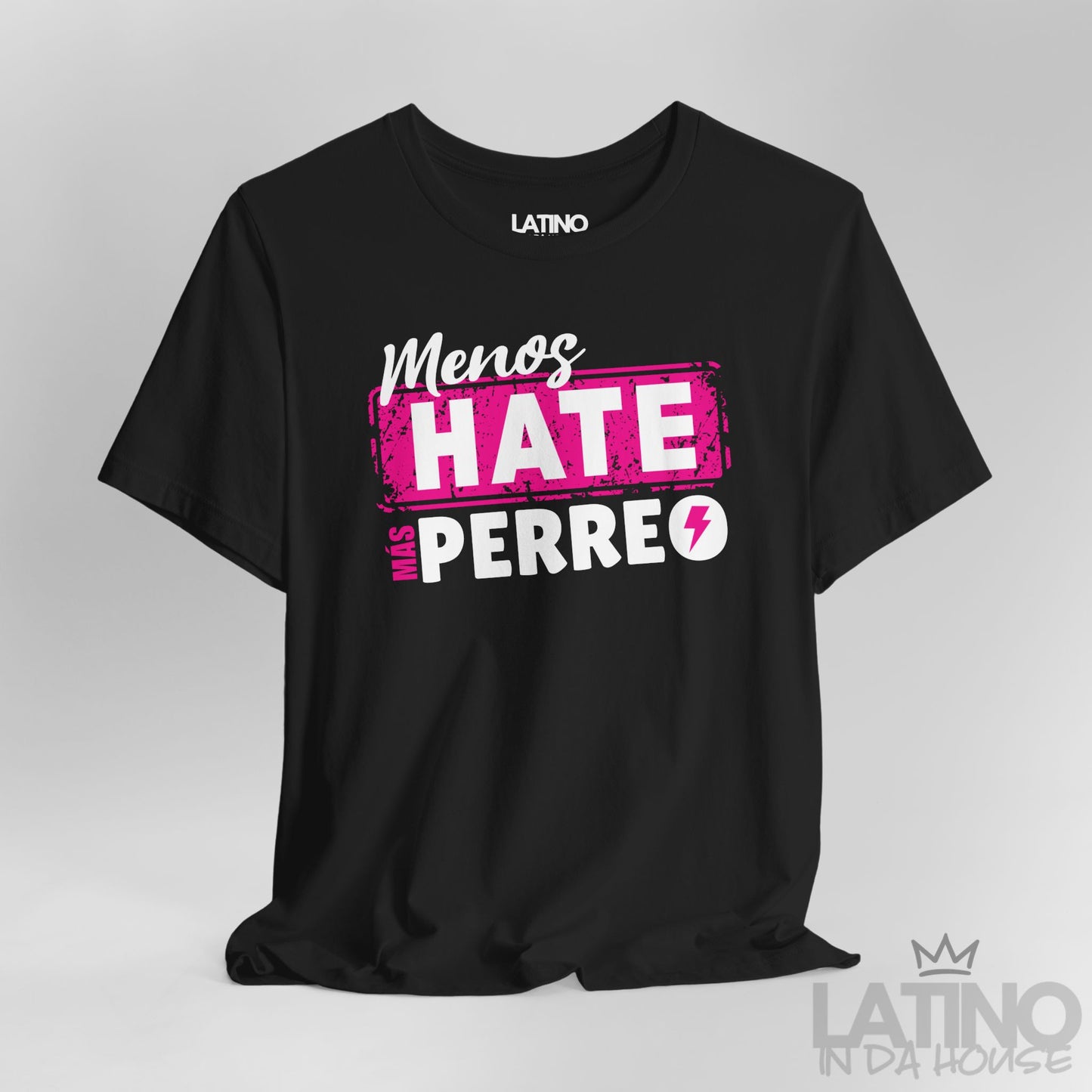 Black graphic tee with pink and white lettering “Menos Hate Más Perreo,” urban Latino streetwear mockup. Latino In Da House 