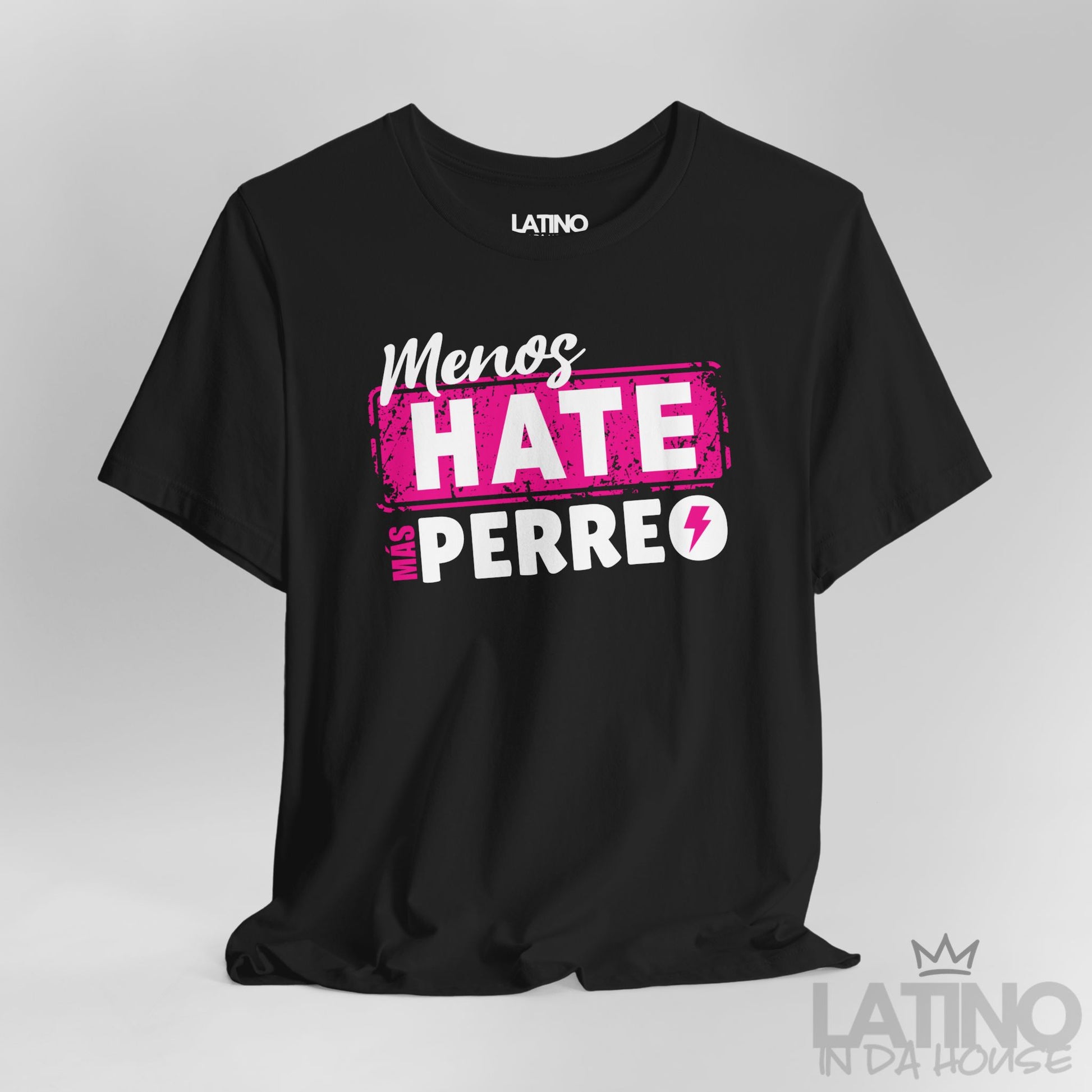Black graphic tee with pink and white lettering “Menos Hate Más Perreo,” urban Latino streetwear mockup. Latino In Da House 