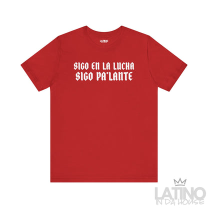 Red T-shirt with bold gothic white text reading “Sigo en la lucha, sigo pa’lante.” Latino In Da House