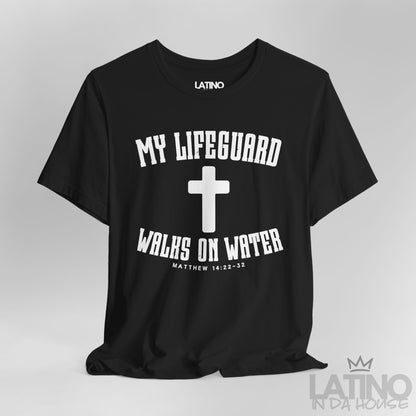 Close up black t-shirt with white cross and text ‘My Lifeguard Walks on Water – Matthew 14:22–32.’ Latino In Da House 