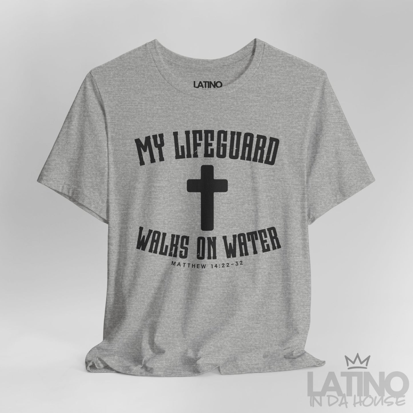 Close up heather grey t-shirt with white cross and text ‘My Lifeguard Walks on Water – Matthew 14:22–32.’ Latino In Da House 