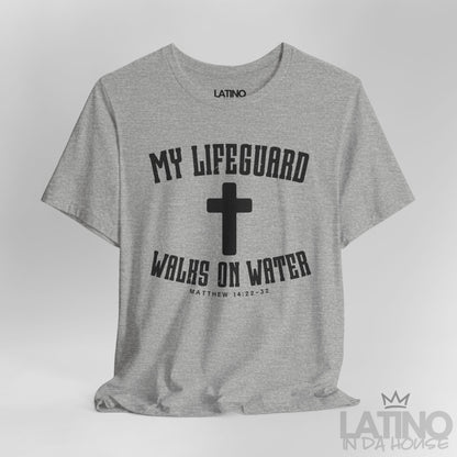 Close up heather grey t-shirt with white cross and text ‘My Lifeguard Walks on Water – Matthew 14:22–32.’ Latino In Da House 