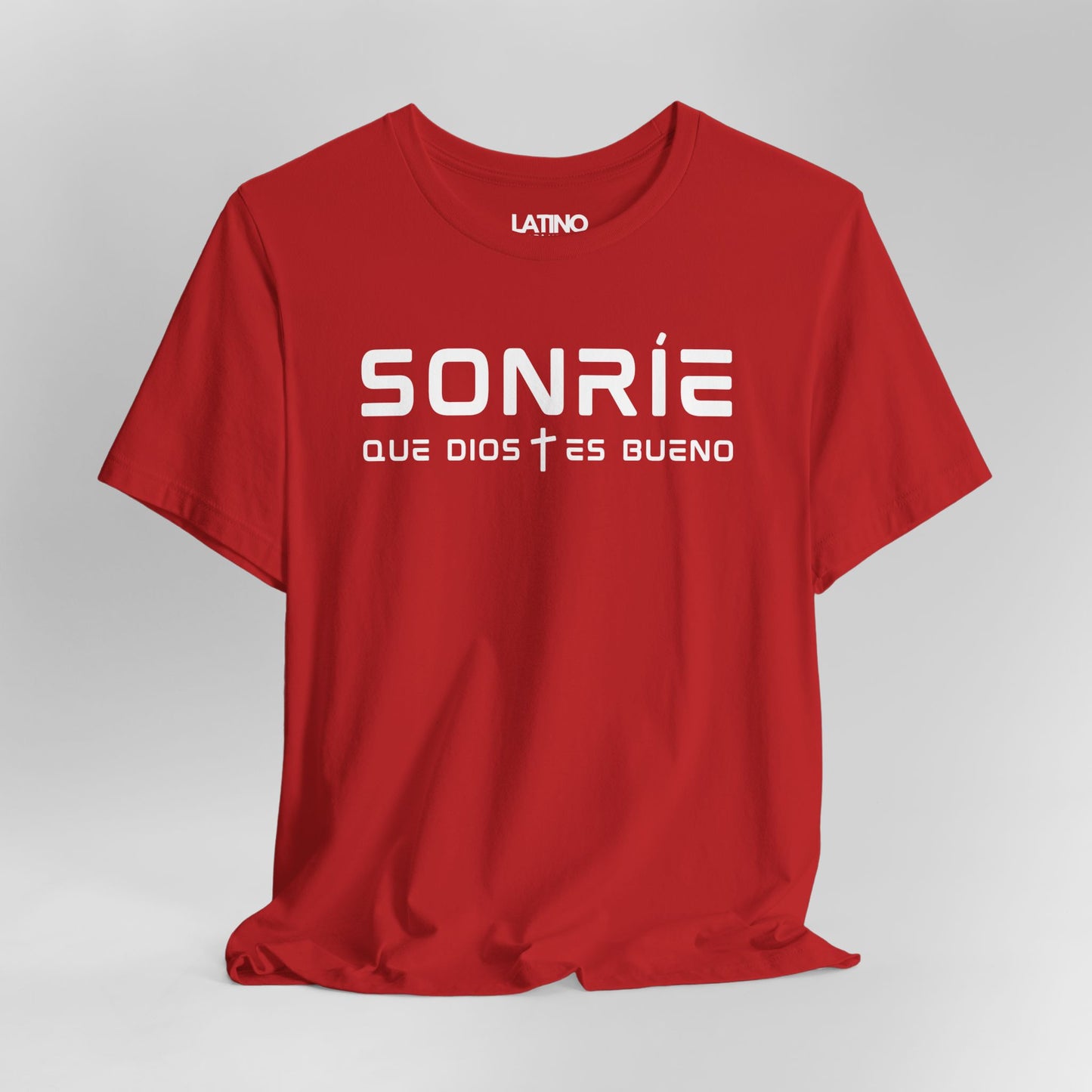 Close-up of Sonrie Que Dios Es Bueno
Red T-Shirt showing minimalist font and cross accent. Latino In Da House