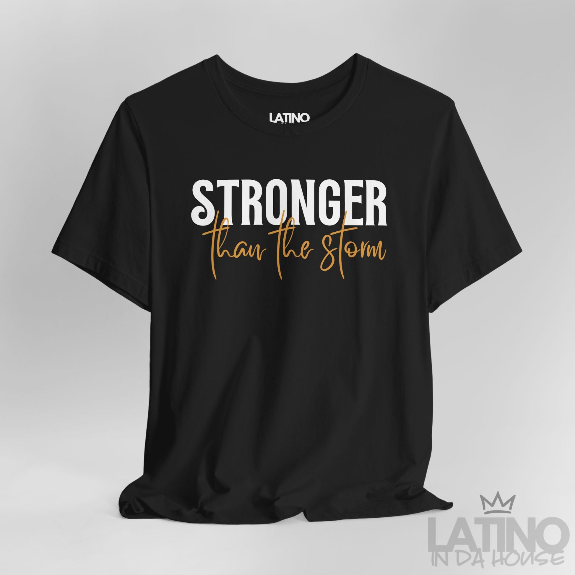 Close Up Stronger Than The Storm t-shirt in black – bold white and script caramel lettering. Latino In Da House 