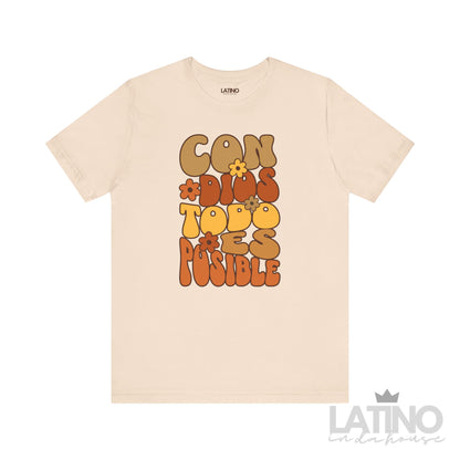 Soft cream T-shirt with retro floral typography reading “Con Dios Todo Es Posible” in brown, orange, and yellow, faith-based Christian design by Latino In Da House.
