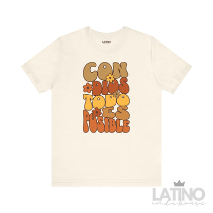 Natural color T-shirt with retro floral typography reading “Con Dios Todo Es Posible” in brown, orange, and yellow, faith-based Christian design by Latino In Da House.