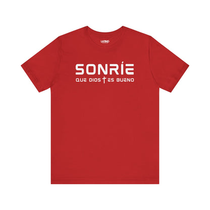 Sonríe Que Dios Es Bueno T-shirt in red with clean white typography and small cross icon. Latino In Da House